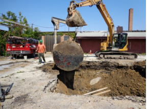 Excavator Removes underground tank from ground